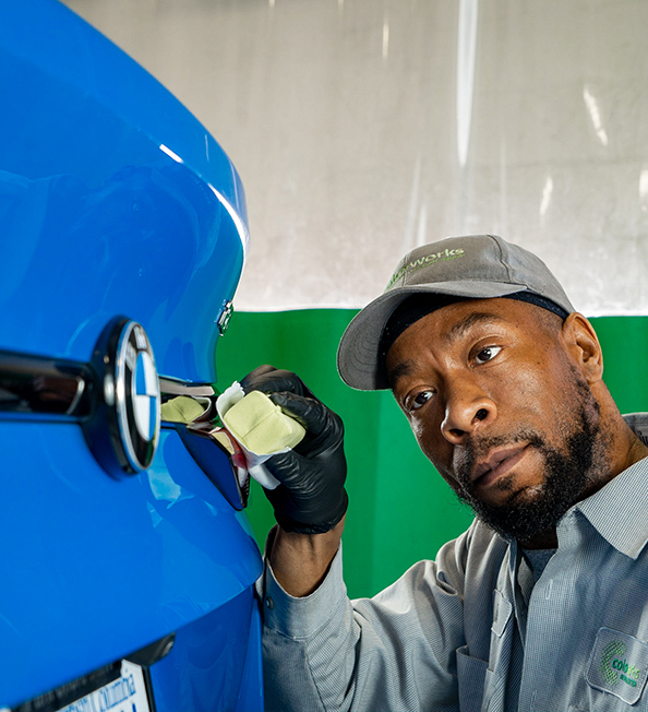 Technician performing exterior vehicle detailing service.