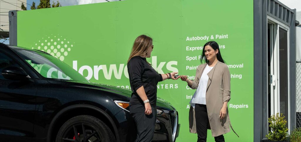 Customer receiving vehicle keys at Colorworks auto service location.