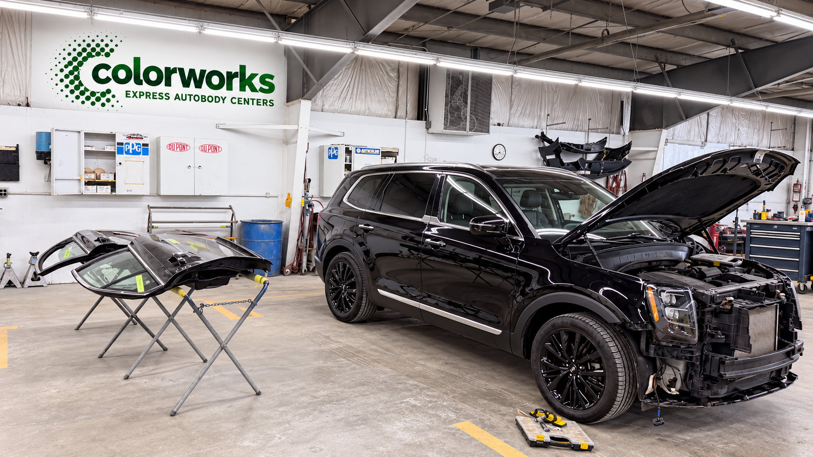 Black Lincoln SUV in a collision repair workshop, with Colorworks Express branding